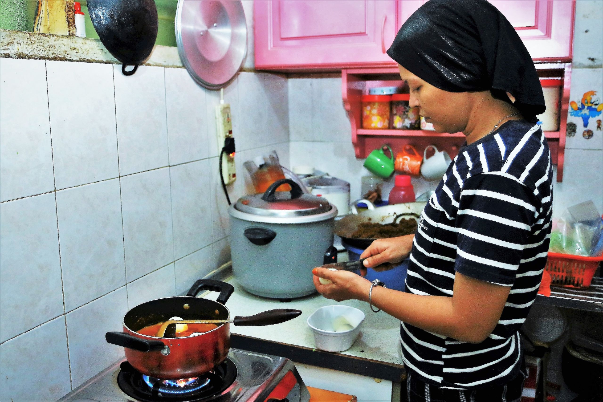 امرأة تطبخ في موقد بماليزيا